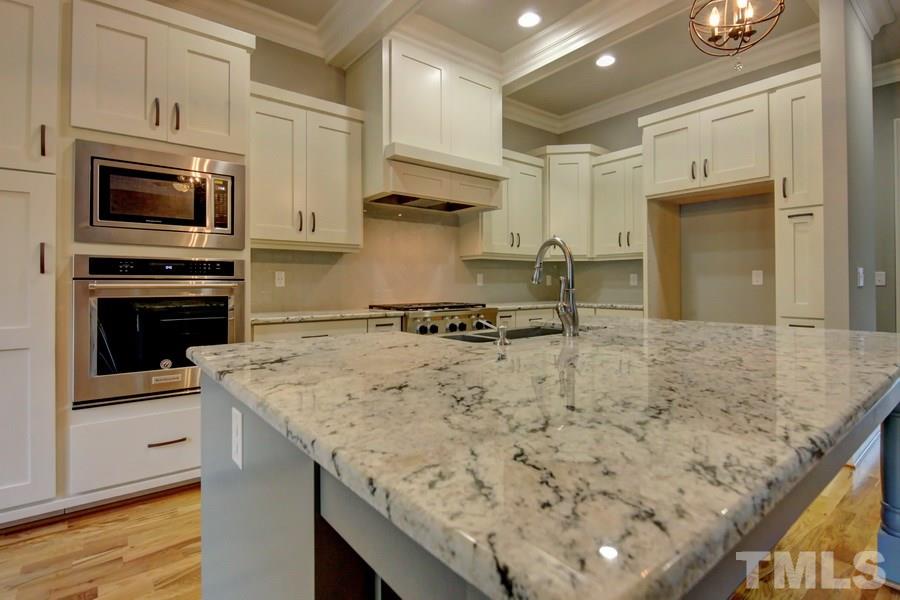 6909 Old Mills Road Fuquay-Varina, NC 27526 - Photo 2 of 25 a kitchen with stainless steel appliances granite countertop a sink and a stove