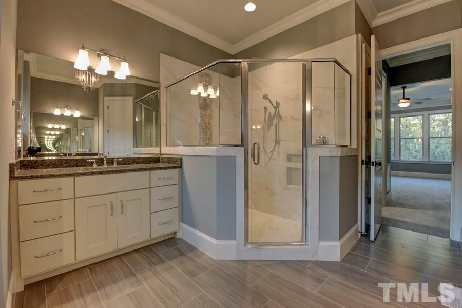 6909 Old Mills Road Fuquay-Varina, NC 27526 - Photo 11 of 25 a bathroom with a shower sink and mirror