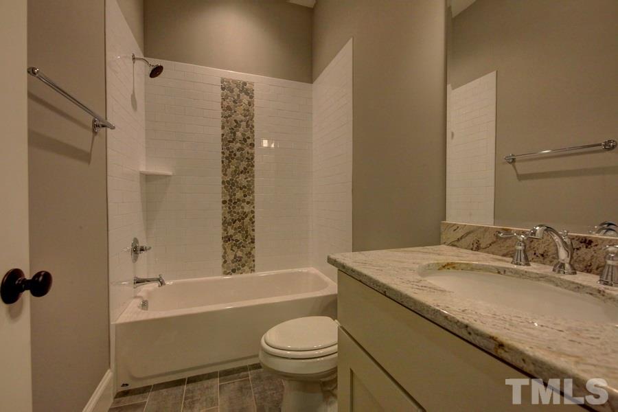 6909 Old Mills Road Fuquay-Varina, NC 27526 - Photo 13 of 25 a bathroom with a granite countertop sink toilet and shower