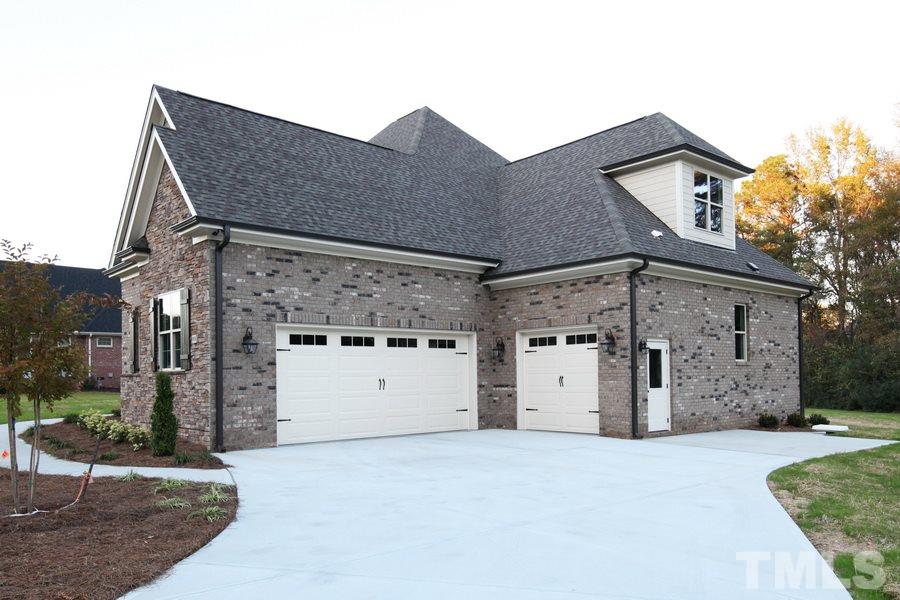 6909 Old Mills Road Fuquay-Varina, NC 27526 - Photo 23 of 25 a front view of a house with a large parking space and a large window