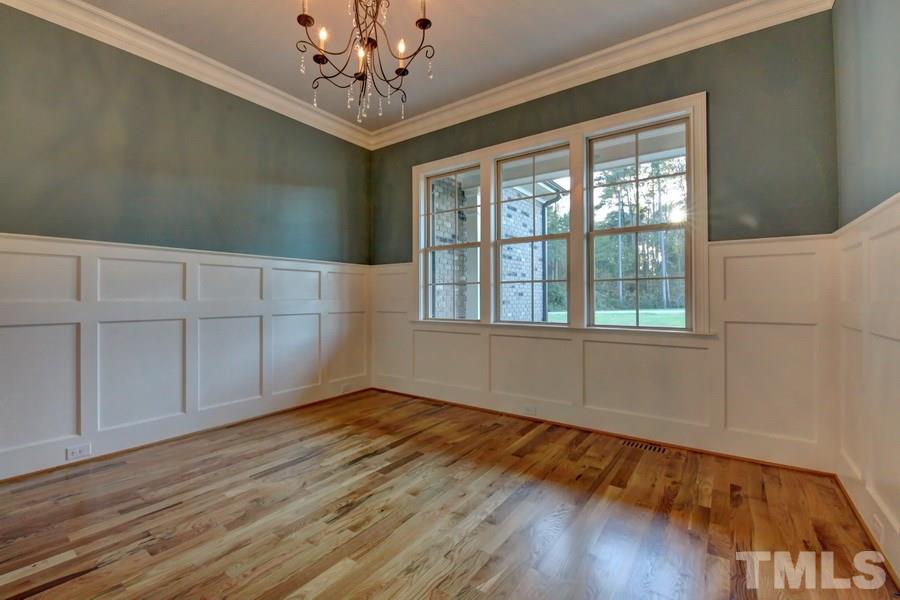 6909 Old Mills Road Fuquay-Varina, NC 27526 - Photo 6 of 25 a view of an empty room with wooden floor and a window