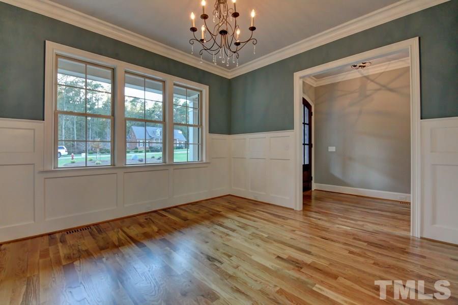 6909 Old Mills Road Fuquay-Varina, NC 27526 - Photo 7 of 25 a view of an empty room with wooden floor and a window