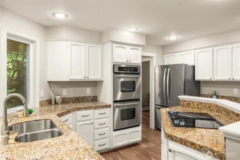 a kitchen with kitchen island granite countertop a refrigerator stove and sink