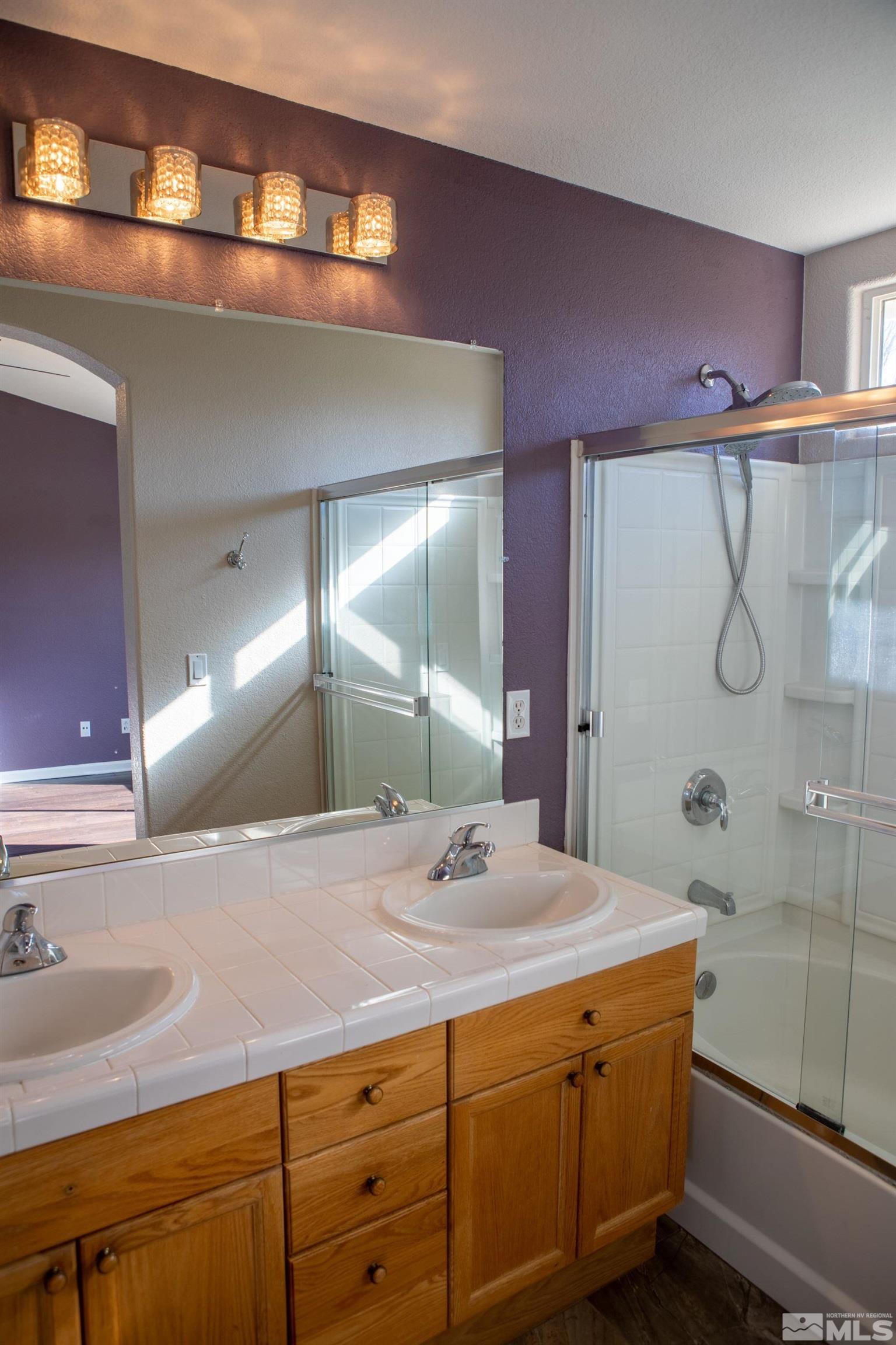1754 River Gorge Drive Reno, NV 89521 - Photo 11 of 18 a bathroom with a granite countertop sink a mirror and a shower