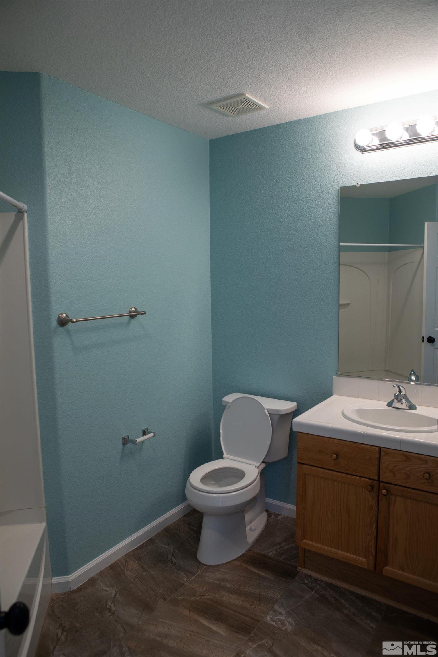 1754 River Gorge Drive Reno, NV 89521 - Photo 14 of 18 a bathroom with a toilet a sink and mirror
