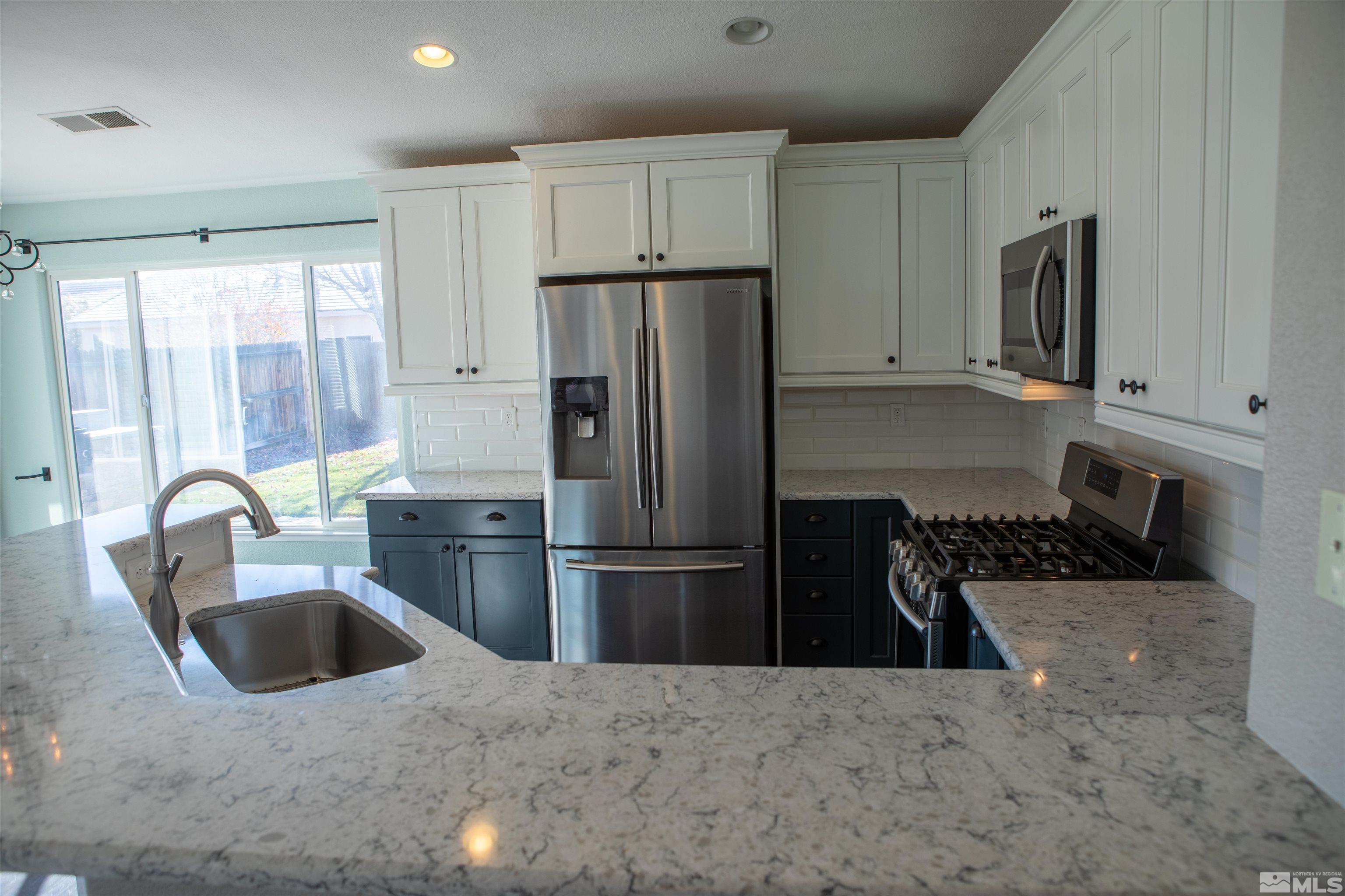 1754 River Gorge Drive Reno, NV 89521 - Photo 8 of 18 a kitchen with a refrigerator sink and white cabinets