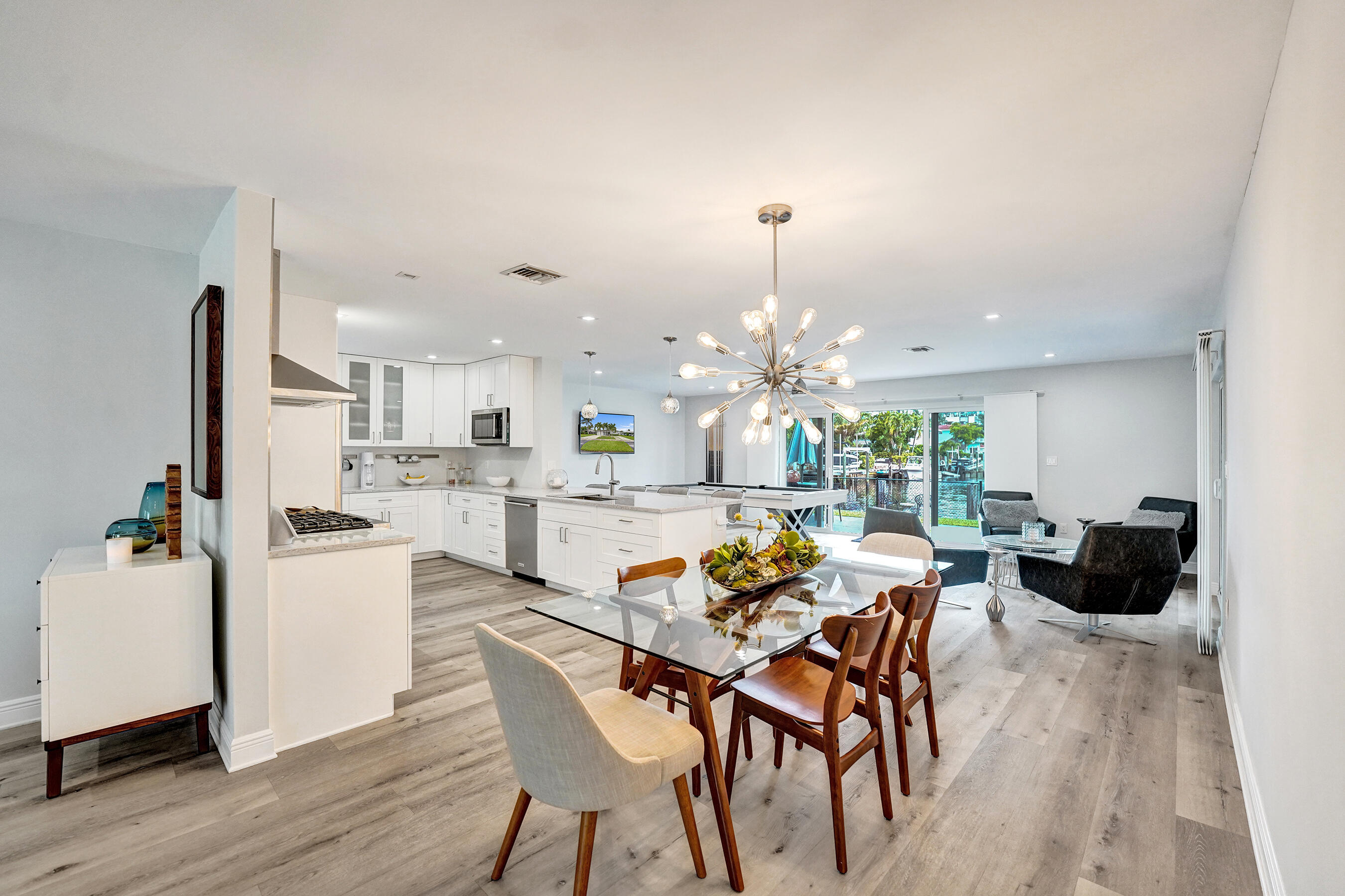 381 Southeast 3rd Street Pompano Beach, FL 33060 - Photo 11 of 41 a kitchen with a dining table chairs and white cabinets