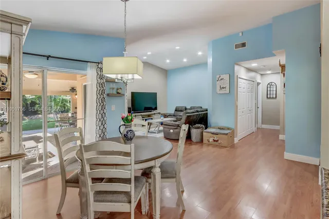 a dining room with furniture a chandelier and wooden floor