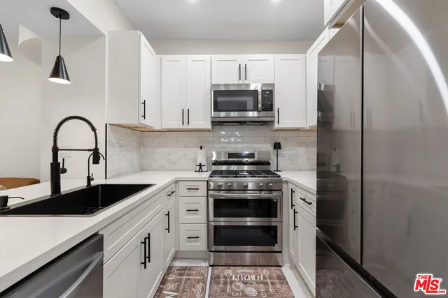 a kitchen with stainless steel appliances granite countertop a sink stove and refrigerator