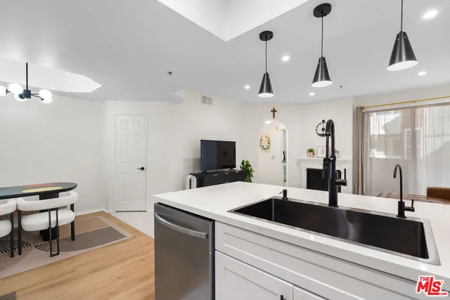 a kitchen with a sink a counter and chairs