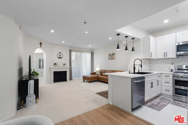 a kitchen with stainless steel appliances kitchen island granite countertop a stove and a sink