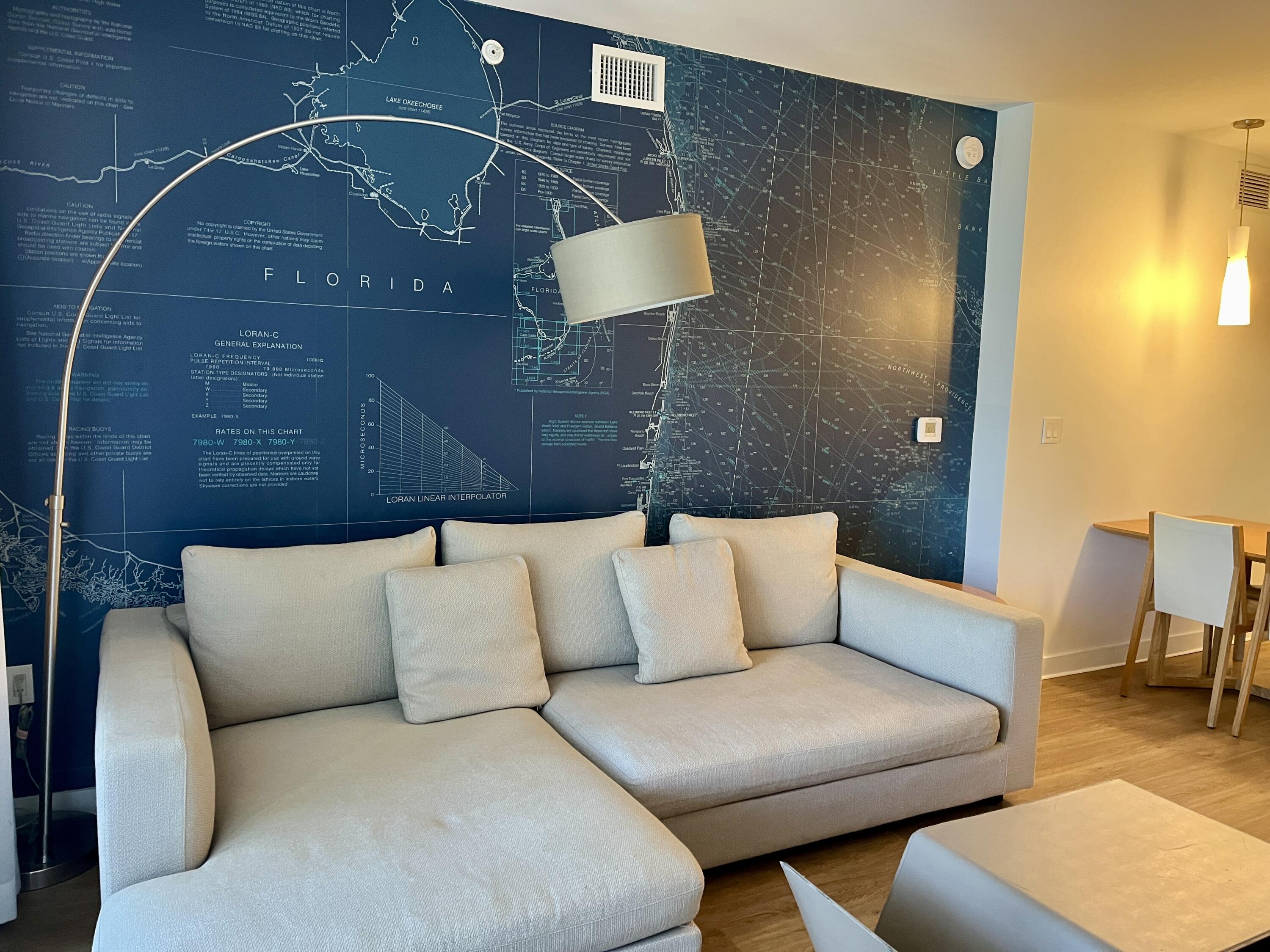 2602 East Hallandale Beach Boulevard, Unit R308 Hallandale Beach, FL 33009 - Photo 3 of 74 a blue couch sitting in a living room with a rug