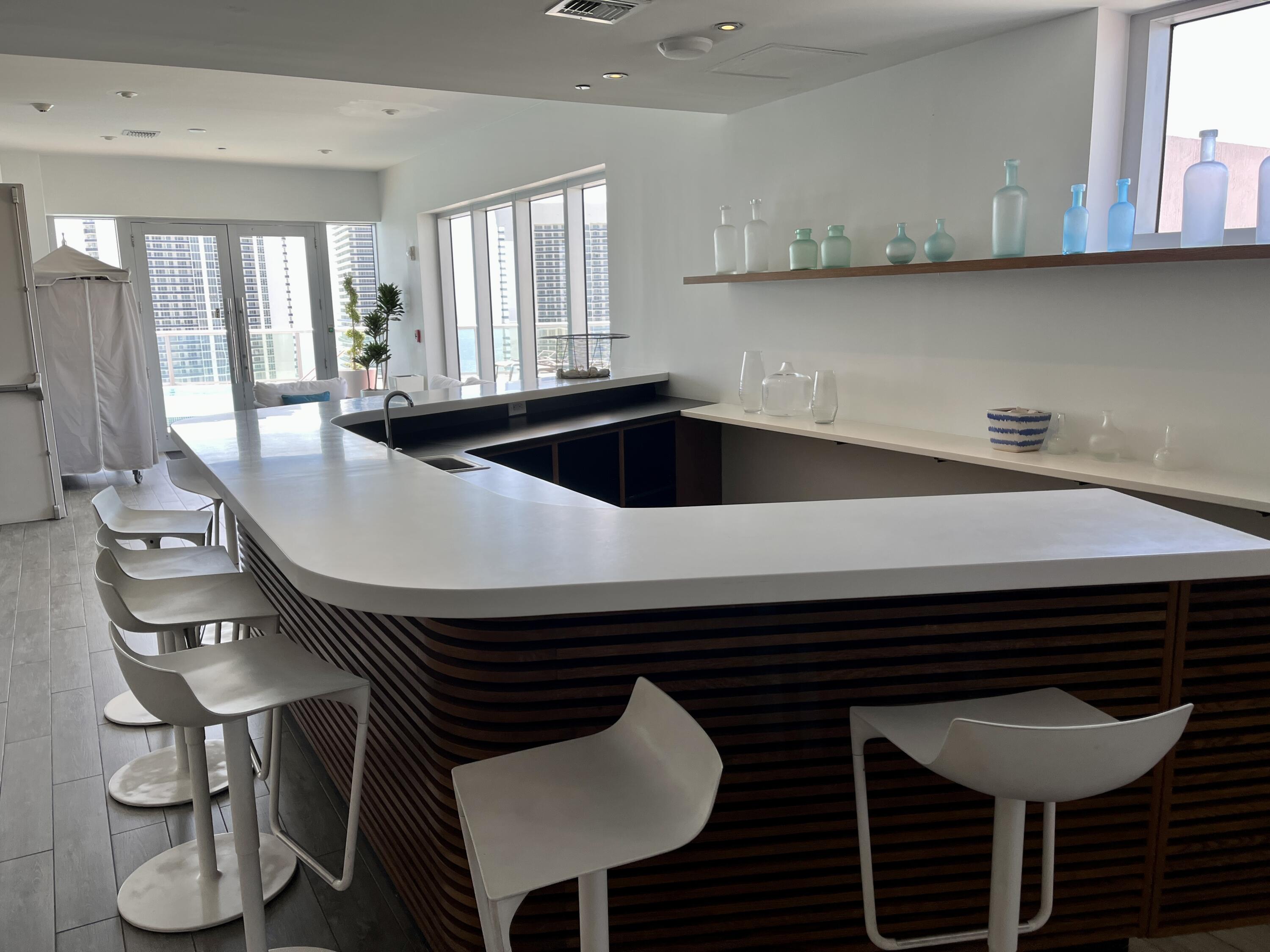 2602 East Hallandale Beach Boulevard, Unit R308 Hallandale Beach, FL 33009 - Photo 41 of 74 a kitchen with a sink a stove and chairs