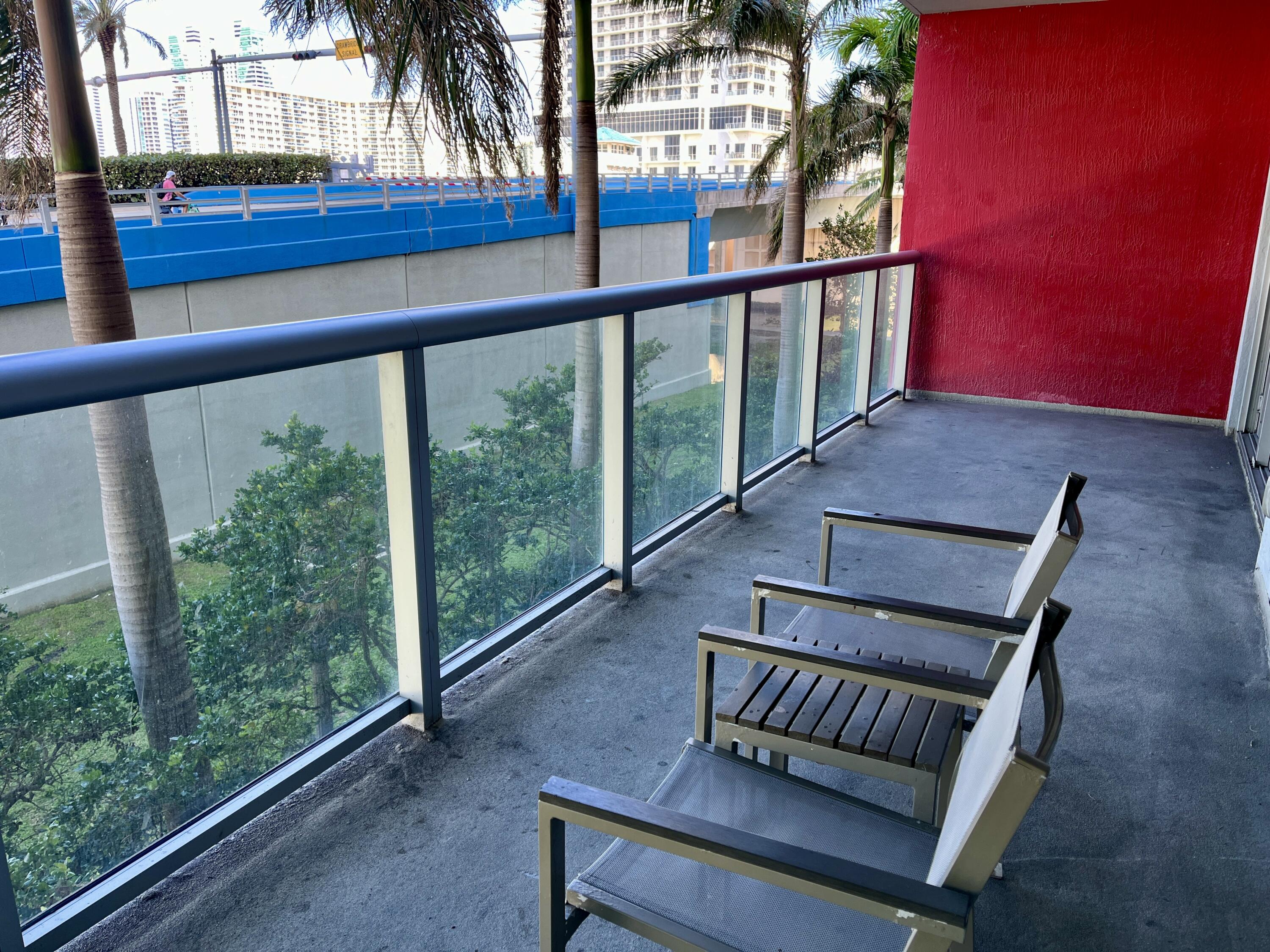 2602 East Hallandale Beach Boulevard, Unit R308 Hallandale Beach, FL 33009 - Photo 9 of 74 a view of balcony with wooden floor and outdoor seating