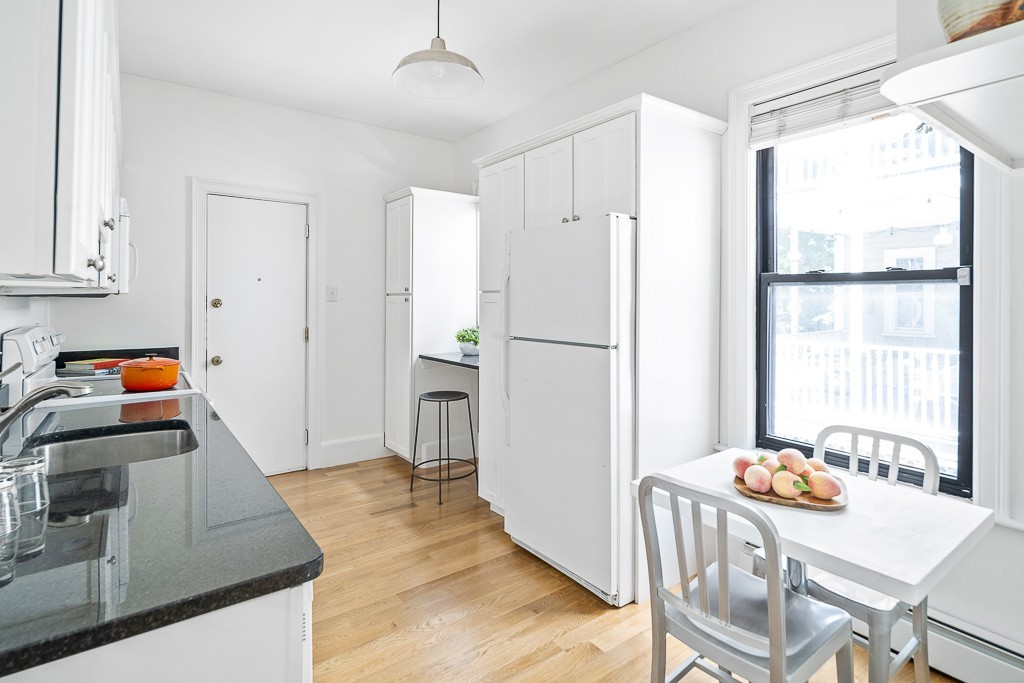 15 Trowbridge Street, Unit 3 Cambridge, MA 02138 - Photo 5 of 14 a kitchen with stainless steel appliances granite countertop a refrigerator a stove a sink a dining table and chairs