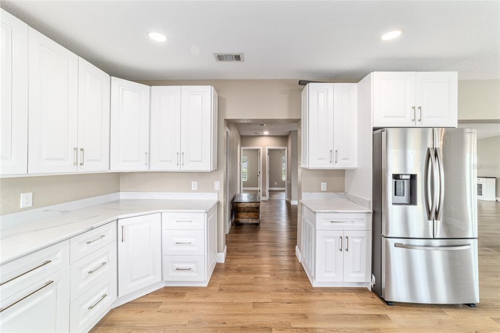 6155 Southeast Stetson Road Belleview, FL 34420 - Photo 19 of 68 a kitchen with white cabinets and stainless steel appliances