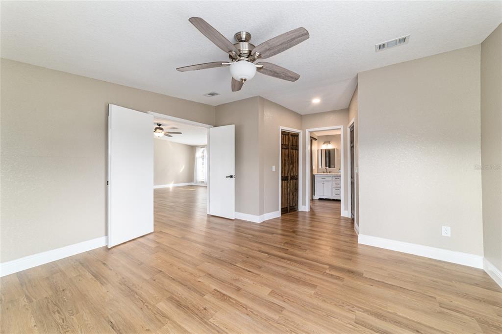 6155 Southeast Stetson Road Belleview, FL 34420 - Photo 20 of 68 a view of an empty room with wooden floor and a ceiling fan