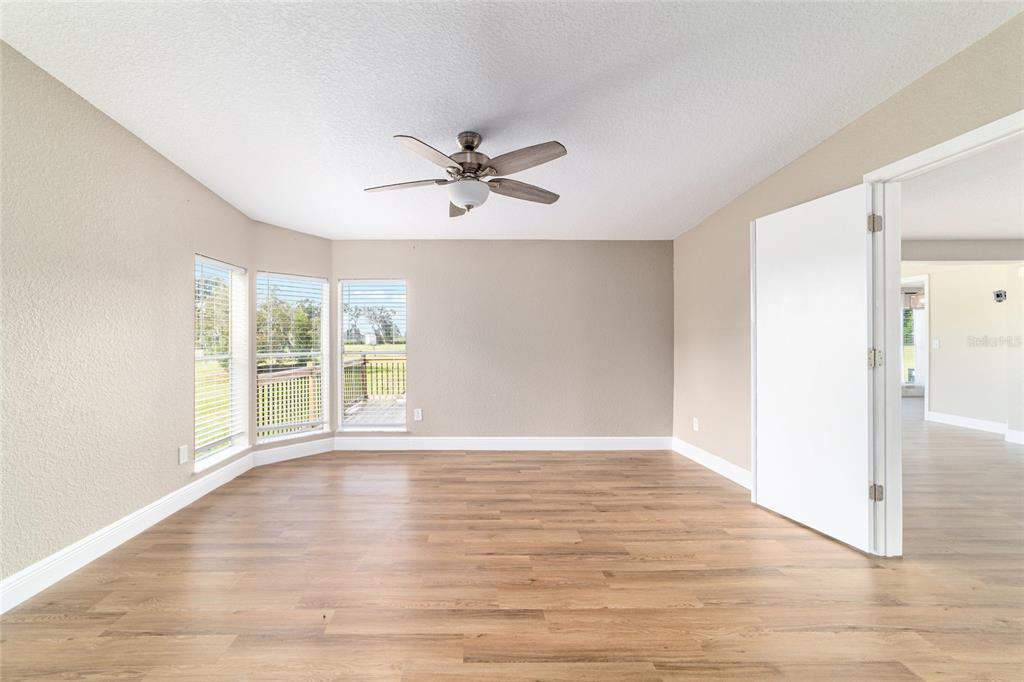 6155 Southeast Stetson Road Belleview, FL 34420 - Photo 22 of 68 a view of empty room with wooden floor and fan