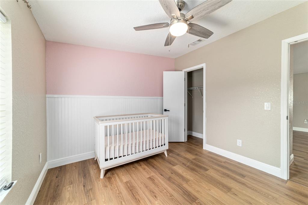 6155 Southeast Stetson Road Belleview, FL 34420 - Photo 31 of 68 an empty room with wooden floor fan and windows