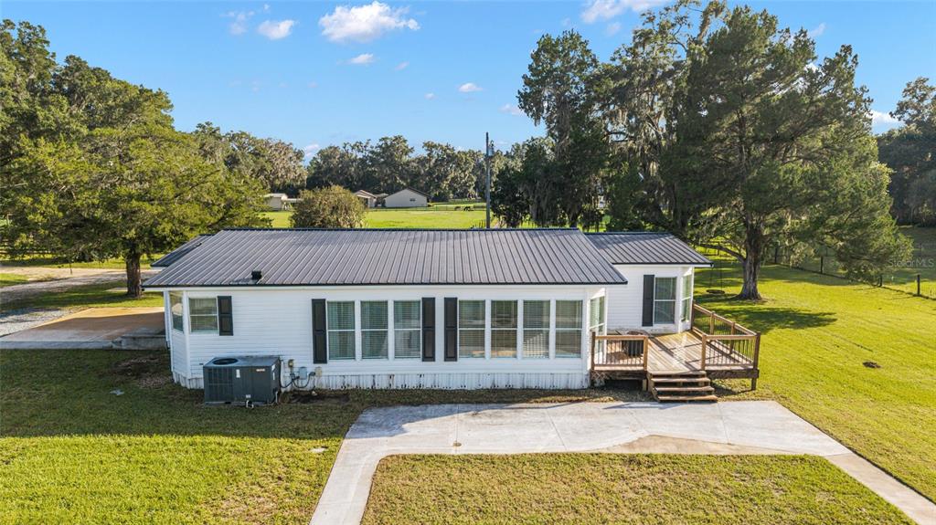6155 Southeast Stetson Road Belleview, FL 34420 - Photo 35 of 68 a view of a house with a swimming pool and sitting area
