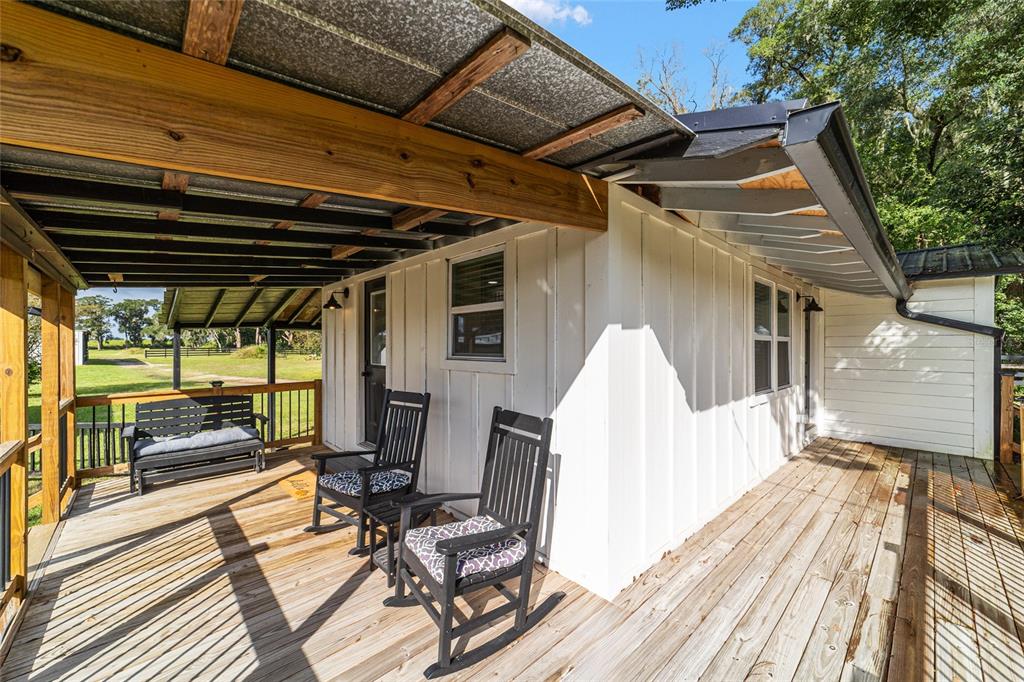 6155 Southeast Stetson Road Belleview, FL 34420 - Photo 38 of 68 a view of a patio with table and chairs with wooden floor and fence