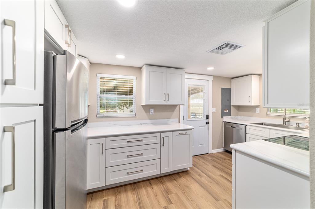 6155 Southeast Stetson Road Belleview, FL 34420 - Photo 43 of 68 a kitchen with a refrigerator and white cabinets