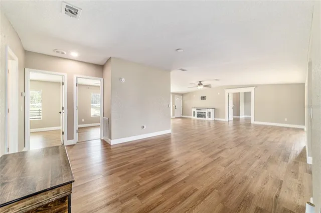 a view of a kitchen with wooden floor electronic appliances and windows
