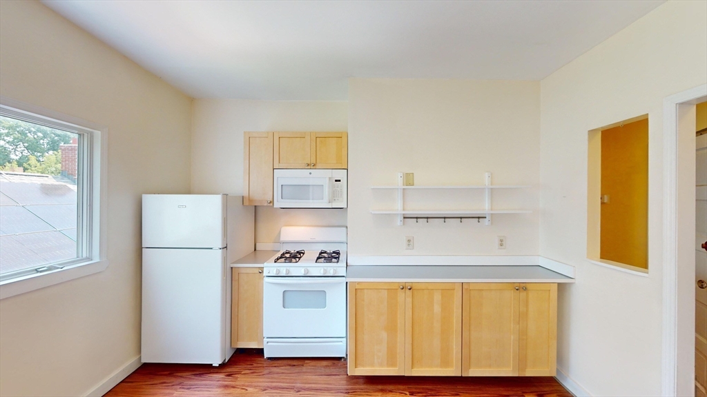 22 Boynton Street Boston, MA 02130 - Photo 26 of 34 a kitchen with white cabinets and wooden floor