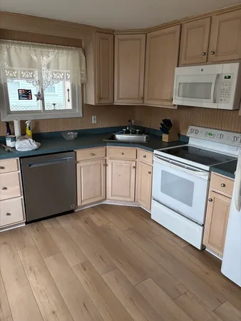 a kitchen with stainless steel appliances granite countertop a stove a sink and white cabinets