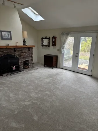 a view of an empty room with a fireplace and a window