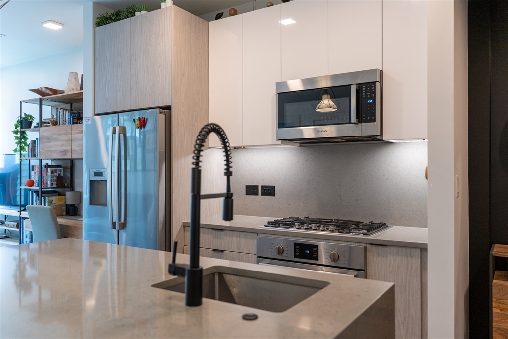 2 Sinclair Road, Unit 202 Boston, MA 02134 - Photo 3 of 23 a kitchen with stainless steel appliances granite countertop a stove and a microwave