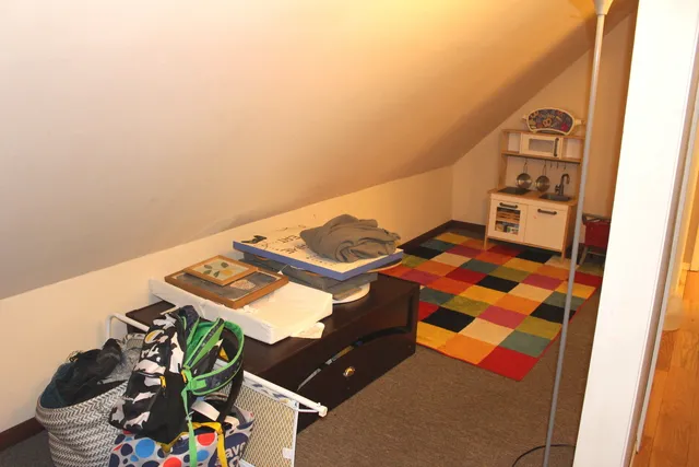 a bed sitting in a bedroom next to a window