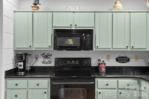 a kitchen with granite countertop a stove and cabinets