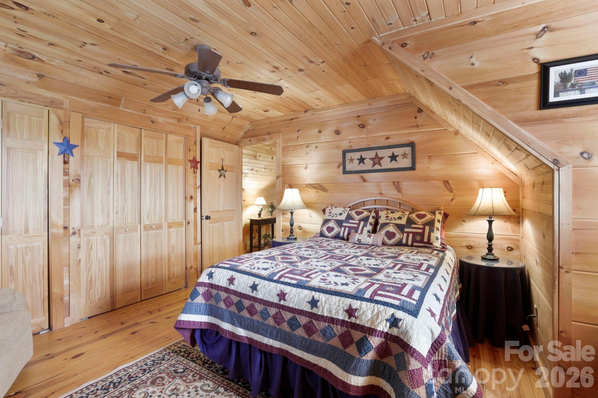 78 Longview Ridge Lake Toxaway, NC 28747 - Photo 30 of 43 a bedroom with a large bed and a chandelier