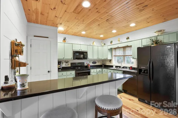 a kitchen with stainless steel appliances granite countertop a sink refrigerator stove and microwave