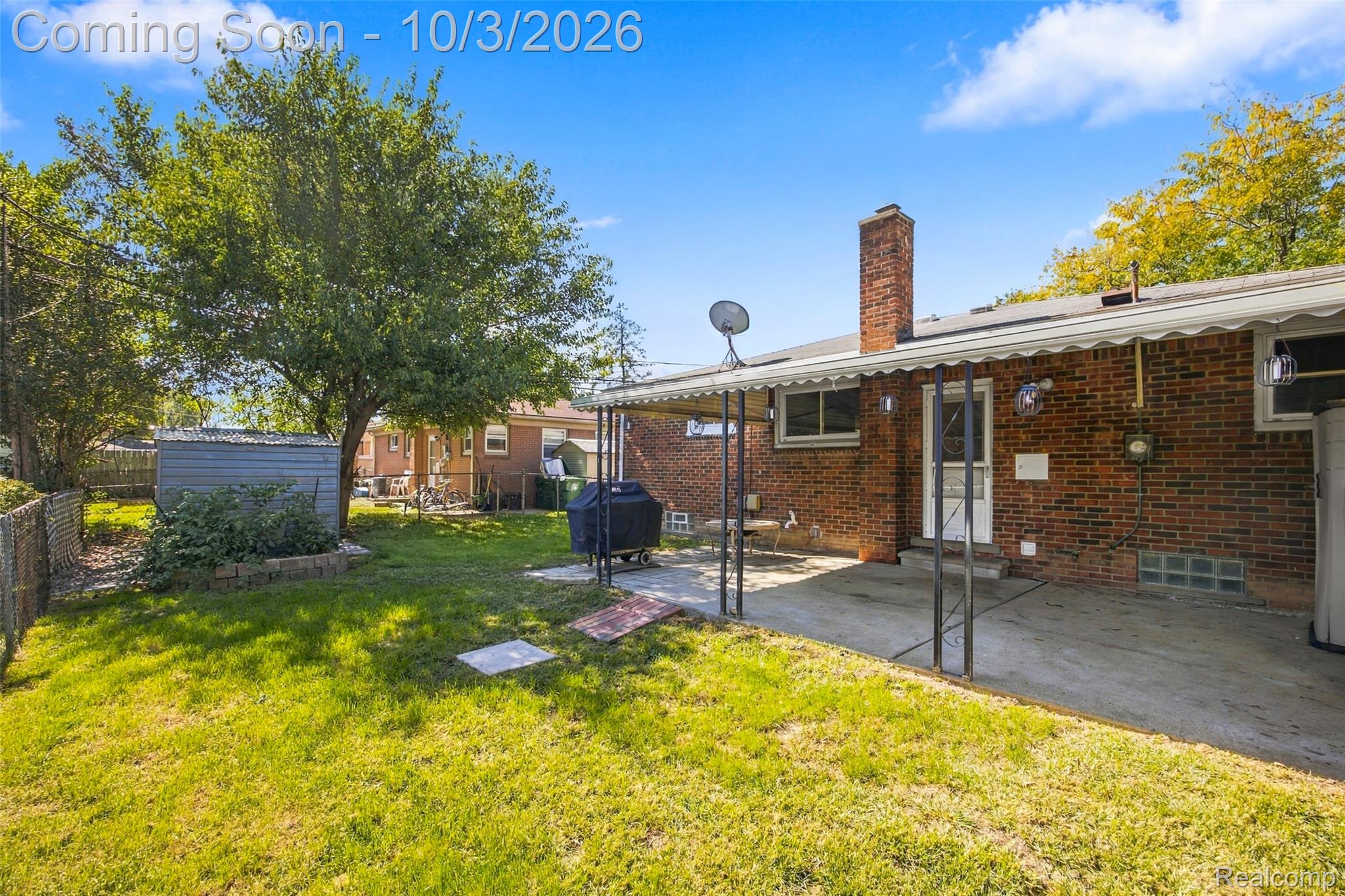556 Henry Ruff Road Garden City, MI 48135 - Photo 30 of 49 Brick exterior with a covered patio, mature tree, and a storage shed