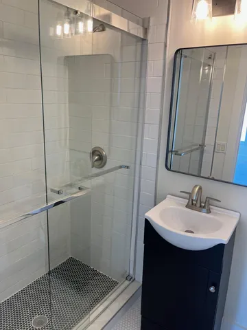 a bathroom with a sink a toilet a mirror and shower