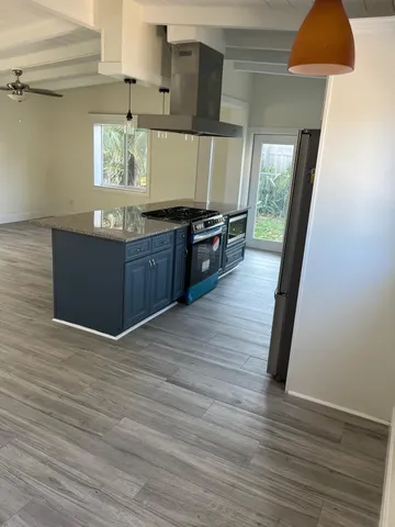 a kitchen with granite countertop wooden floors and a sink