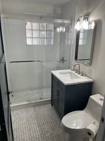 a bathroom with a sink vanity mirror and toilet