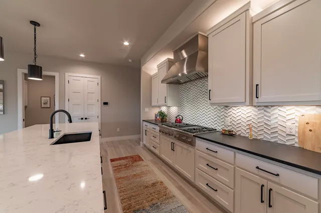 a kitchen with granite countertop white cabinets and sink
