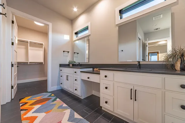 a bathroom with double sink and a mirror