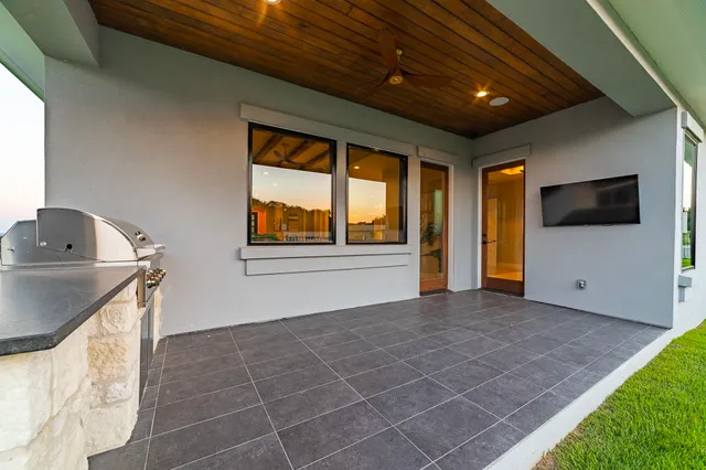 a view of an empty room with a window and kitchen