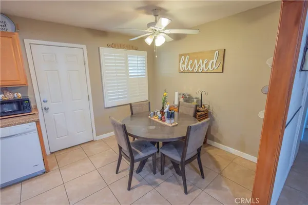 a view of a dining room with furniture and a chandelier fan