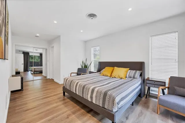 a bedroom with a bed and wooden floor