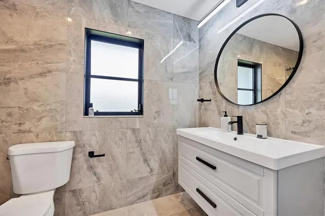 a bathroom with a sink mirror and toilet