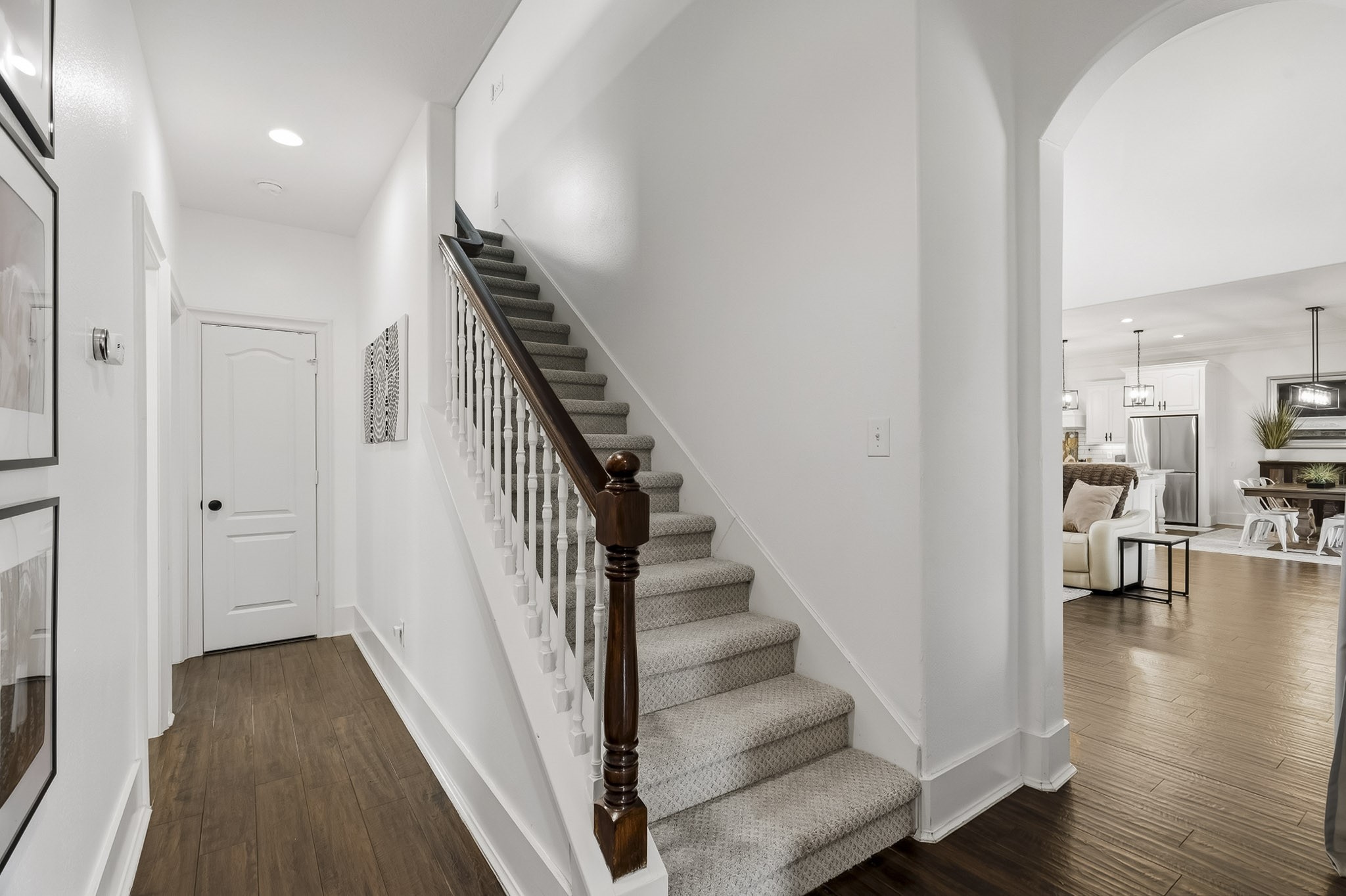 3103 Brundrett Road Wallis, TX 77485 - Photo 25 of 45 A warm and welcoming hallway with beautiful wood flooring and crisp white walls leads to 3 Secondary Bedrooms, while the classic staircase leads upstairs to the spacious Game & Media Rooms. The open layout provides an easy flow into the Family Room, Kitchen and Dining areas beyond.