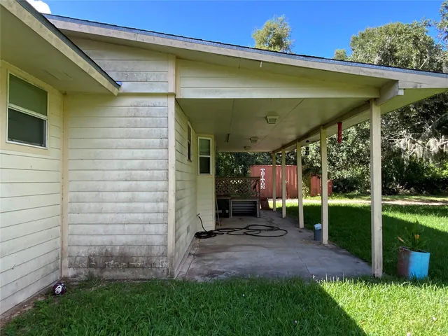 a view of a patio with table and chairs under an umbrella