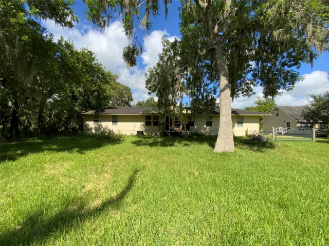 a yellow house with trees in front of it