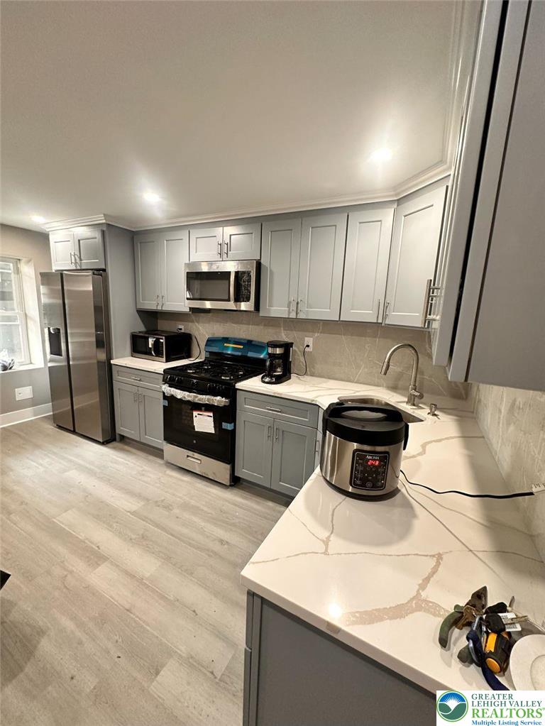 44 South Locust Street Mount Carmel, PA 17851 - Photo 4 of 18 a kitchen with stainless steel appliances a sink a stove a microwave a refrigerator a sink and cabinets