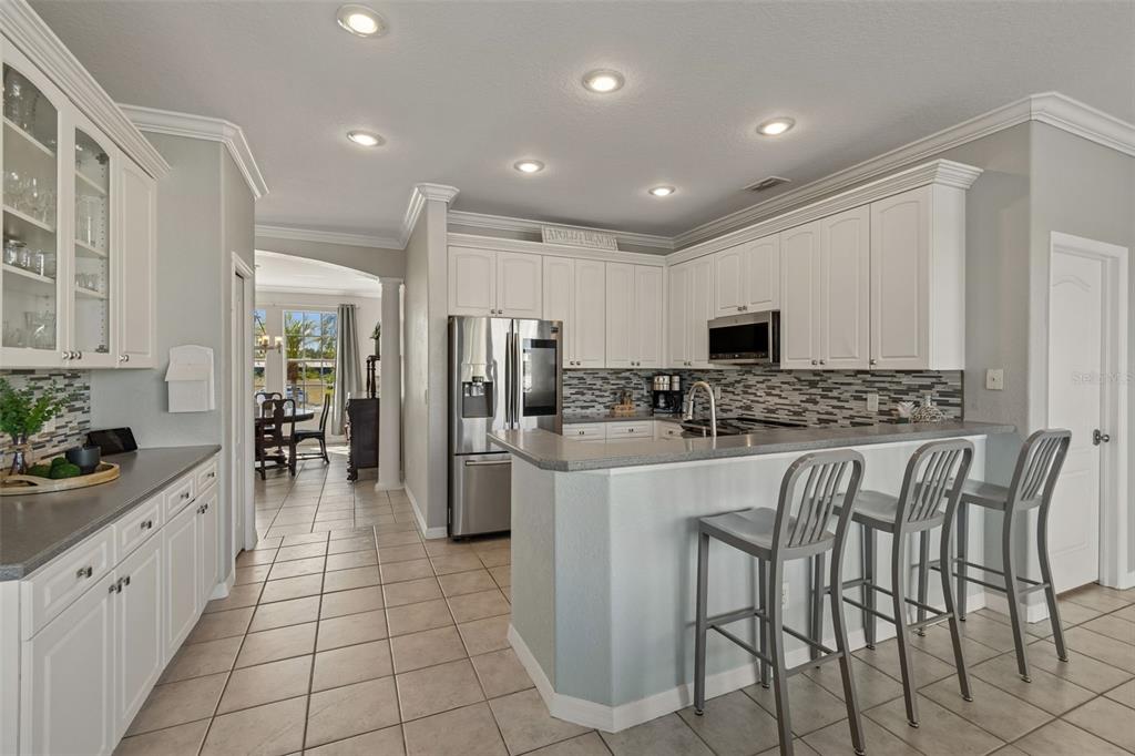 703 Bunker View Drive Apollo Beach, FL 33572 - Photo 10 of 49 a kitchen with stainless steel appliances kitchen island granite countertop a refrigerator and a stove top oven